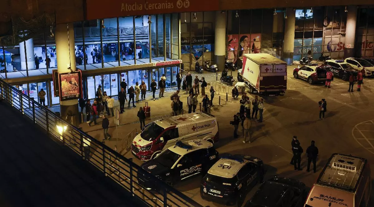 Ambulanțe și mașini de poliție sunt parcate în fața gării Atocha, în timp ce mulți călători se pregătesc să petreacă noaptea înăuntru, în urma unei pene masive de curent care a afectat întreaga peninsulă Iberică și sudul Franței, la Madrid, pe 28 aprilie 2025
