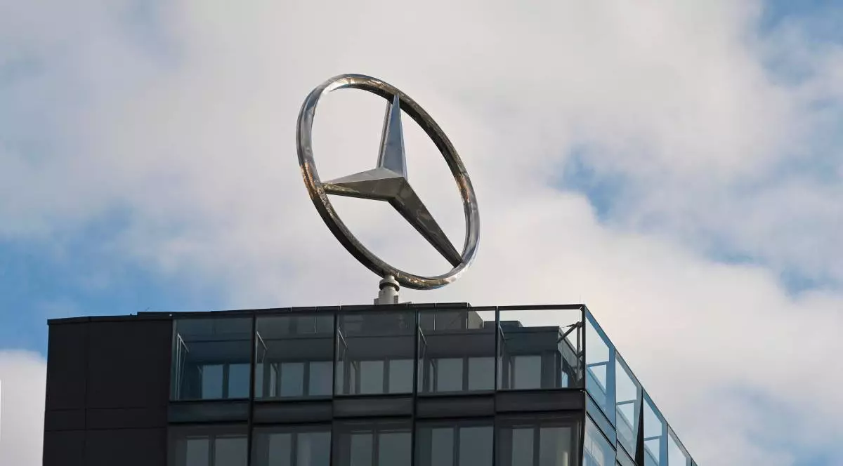 emblema Mercedes-Benz, lucioasă și metalică, este montată pe o cladire de birouri
