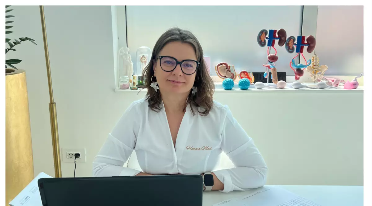 fertilizare in vitro: poza cu doamna Dr. Marilena Blu, in cabinet, asezata pe scaun, avand parul saten, purtand ochelari si o camasa alba