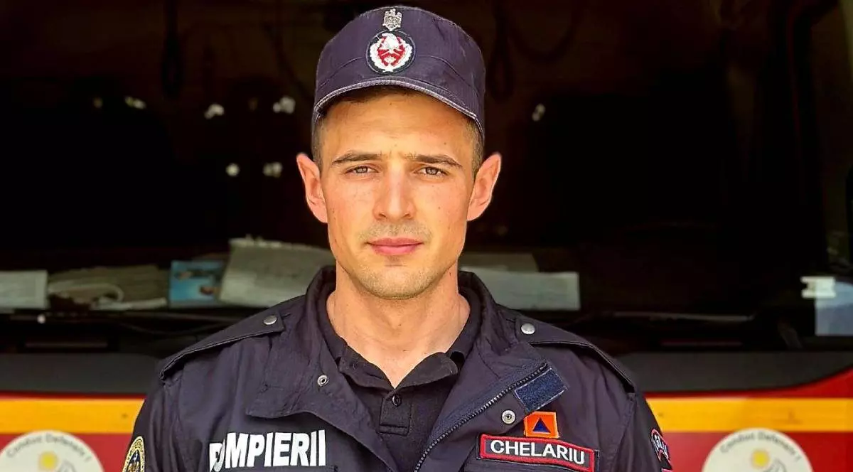 Poză cu pompierul din cadrul ISU Brașov care a intervenit la accident. Este îmbrăcat în uniformă, iar în spate se află o autospecială