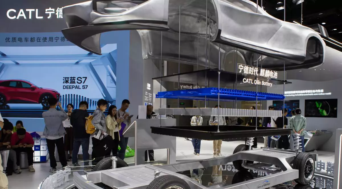 Stand de expoziție al companiei chineze CATL, lider mondial în producția de baterii pentru vehicule electrice. În prim-plan este prezentat un model demonstrativ al unui șasiu de mașină electrică. Pe fundal vizitatorii expoziției privesc panouri informative și reclame