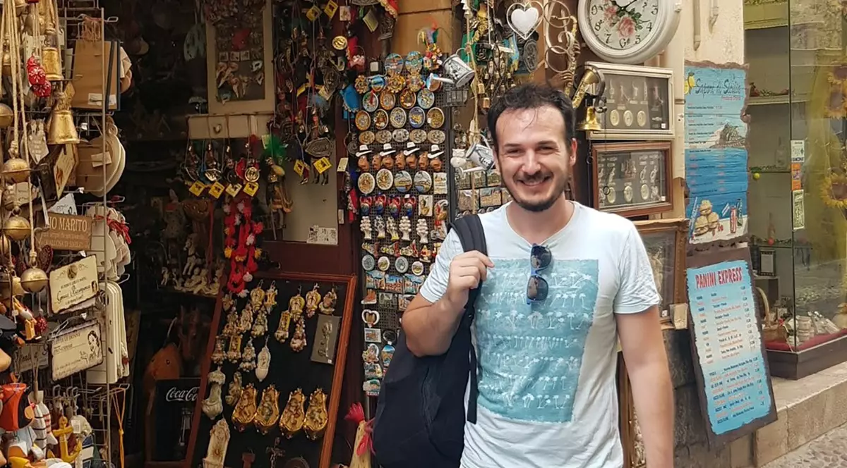 Un barbat cu rucsac in spate intr-un bazar