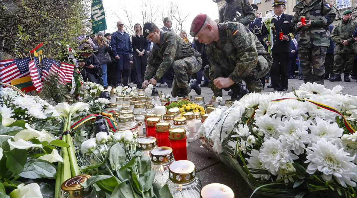Soldați NATO cu flori și lumânări, la Vilnius, aduc un omagiu celor 4 militari americani morți. FOTO: Profimedia.