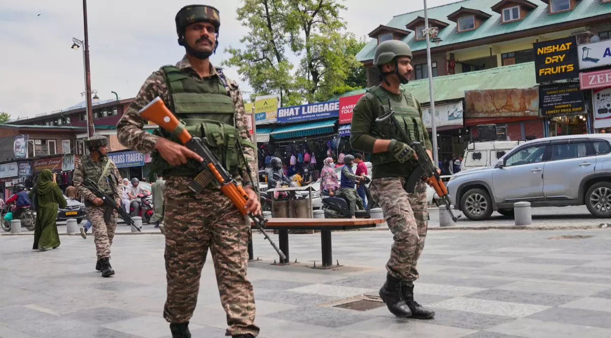 În imagine sunt ilustrați soldați militari în timp ce patrulează pe stradă