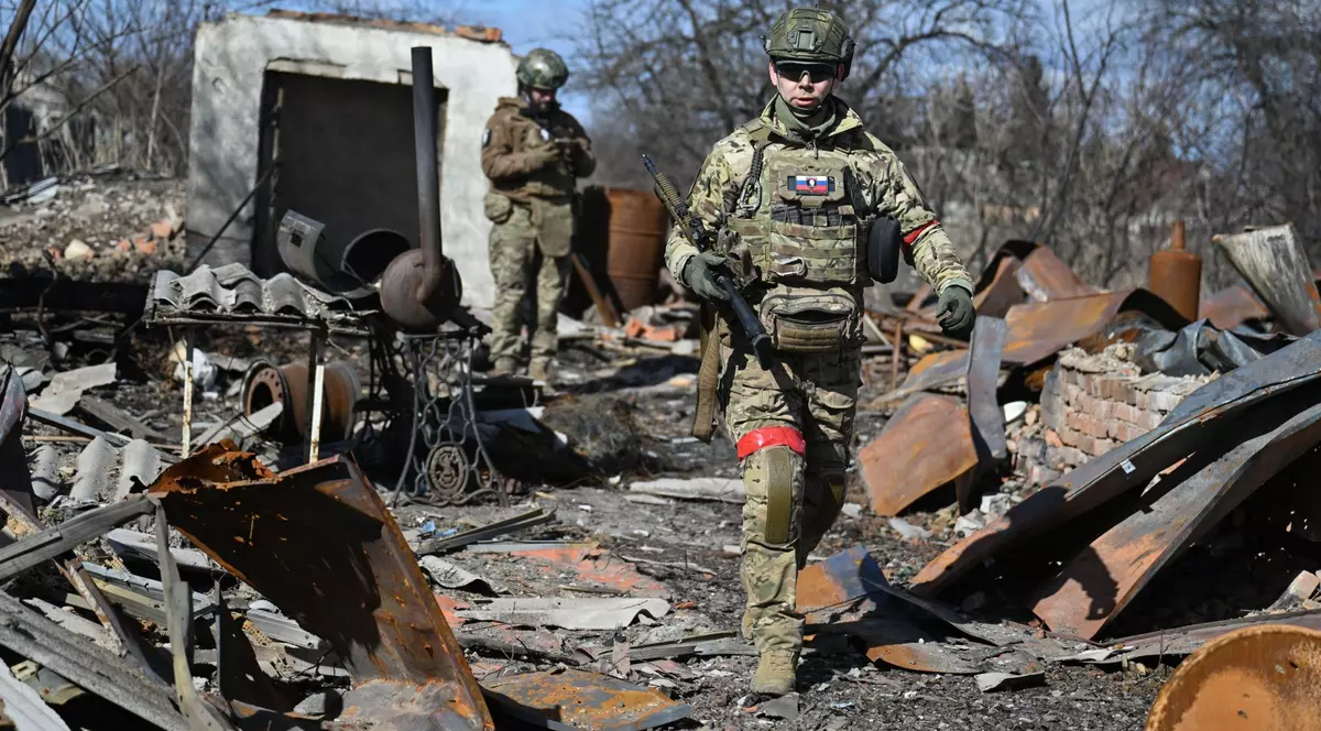 Poză cu doi soldați ruși aflați în Sudja. În jurul lor sunt mai multe obiecte distruse în urma atacurilor