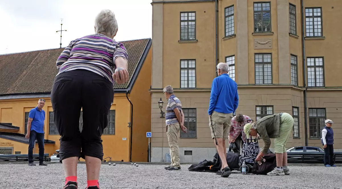 Oameni de difeite vârste în curtea interioara a unei clădiri din Suedia, Stockholm.