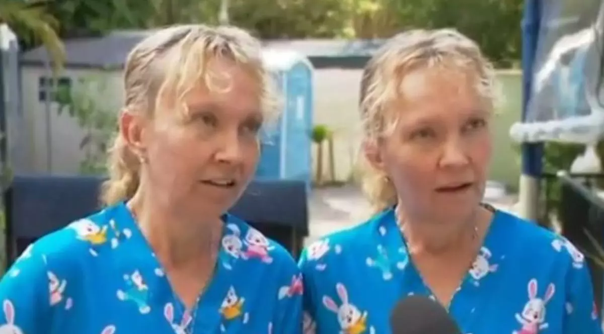 Două surori gemene, blonde, îmbrăcate în trucouri albastre cu imprimeu cu iepurați