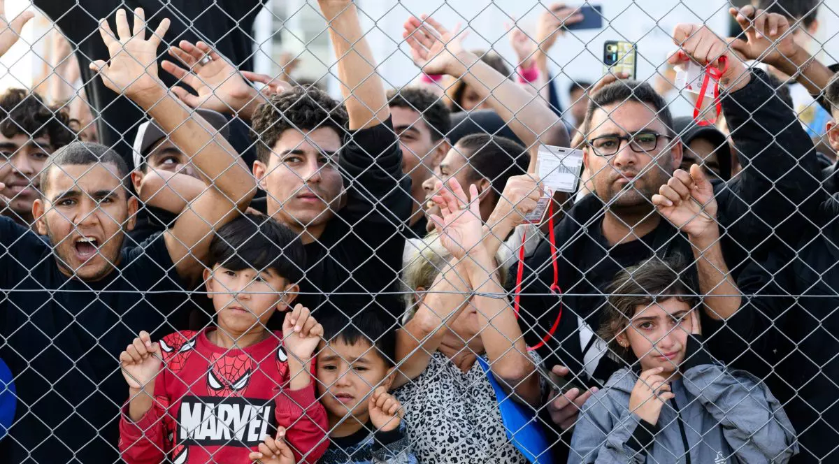 Tabără de imigranți din Grecia, copii și tineri în spatele unui gard.