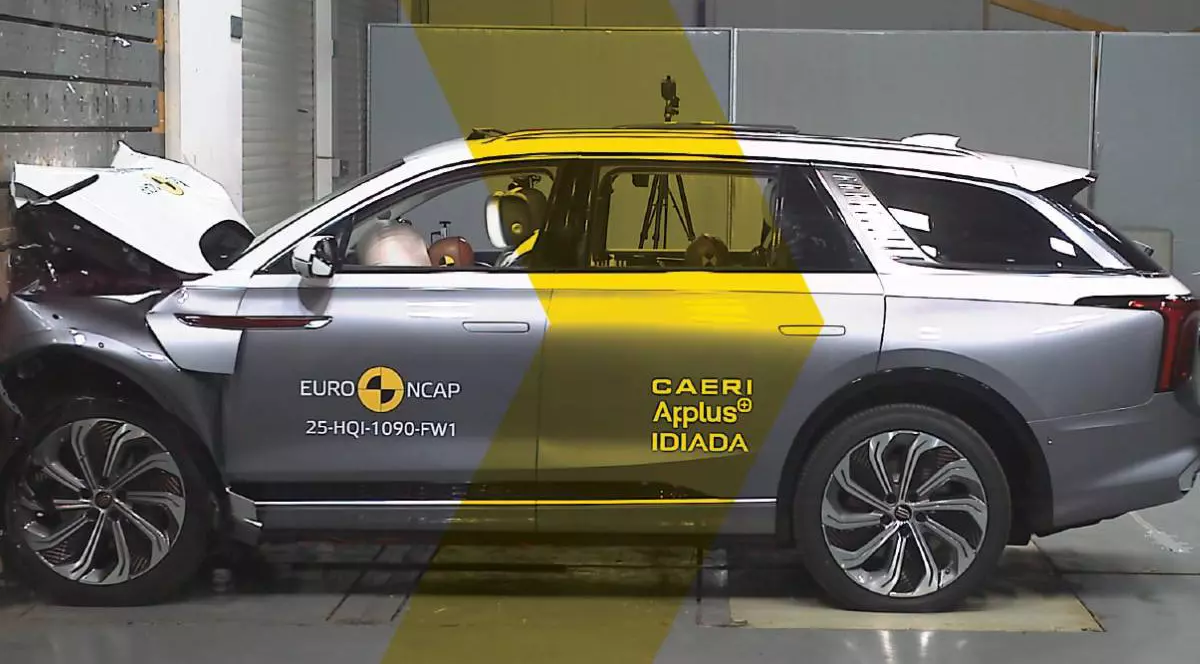 masina electrica de culoare gri in urma unui test auto, cu partea din fata lovita de un perete