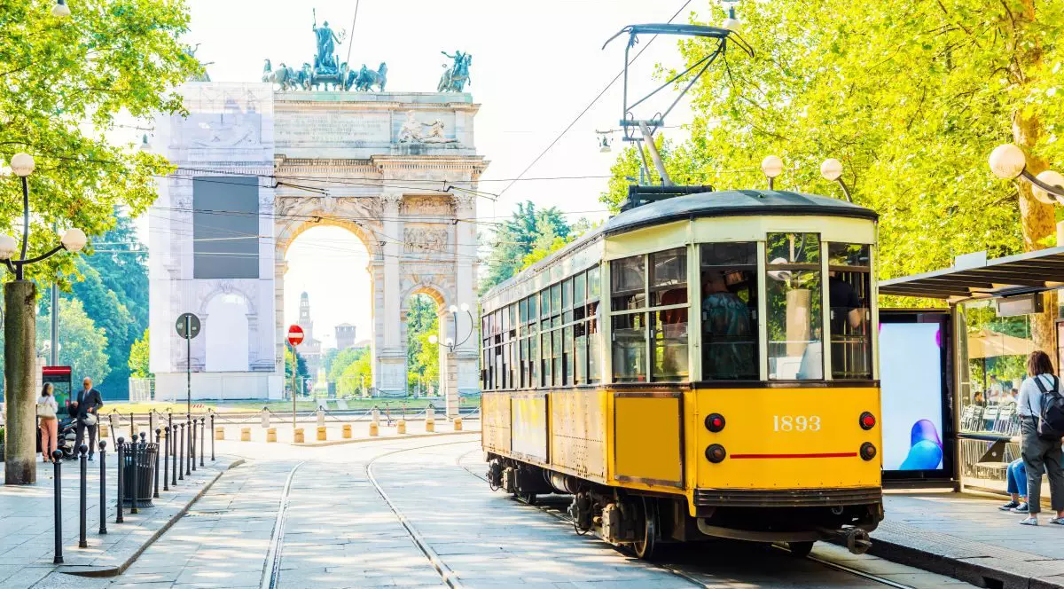 Vedere de la Arcul Păcii (Arco della Pace) din Milano, Italia, iar în prim-plan este un tramvai galben care a ajuns în stație