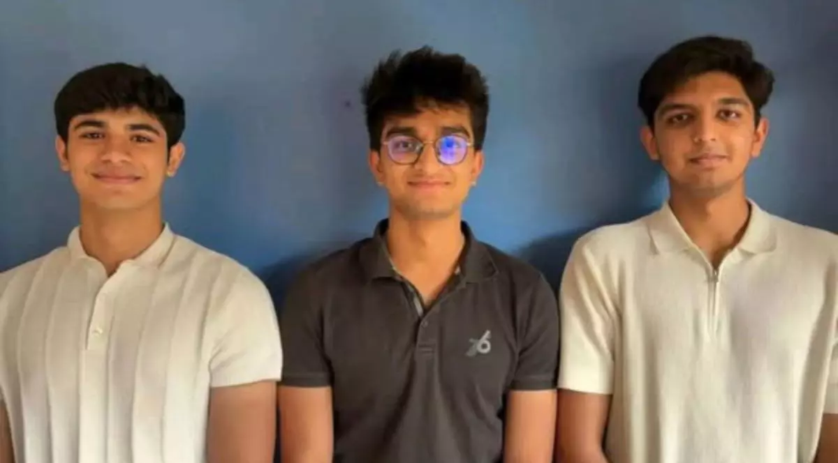 trei băieti din India stau la poza la un perete albastru - Dhruv Chaudhary, Mithran Ladhania și Mridul Jain au lucrat împreună pentru a construi un frigider alimentat cu sare.