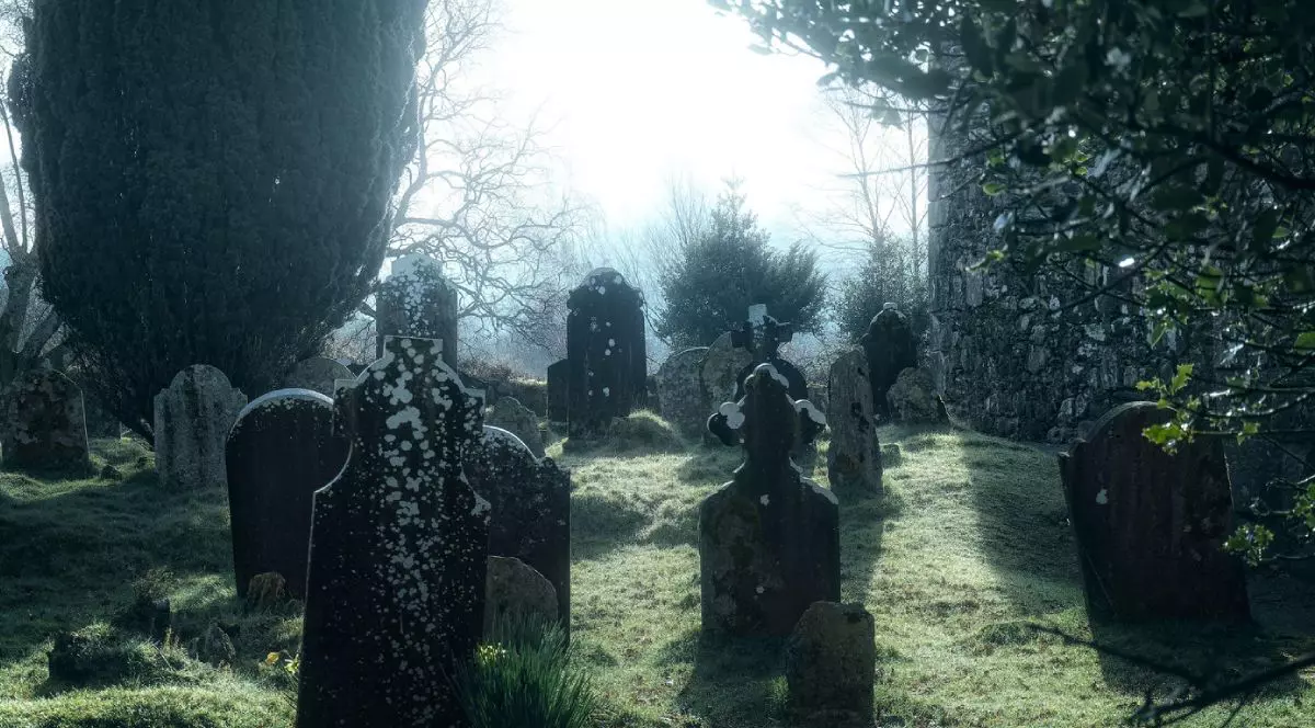 Imagine macabr[ cu pietre funerare negre, ]nntr-un cimitir vechi, la mijloc o zona luminoasa