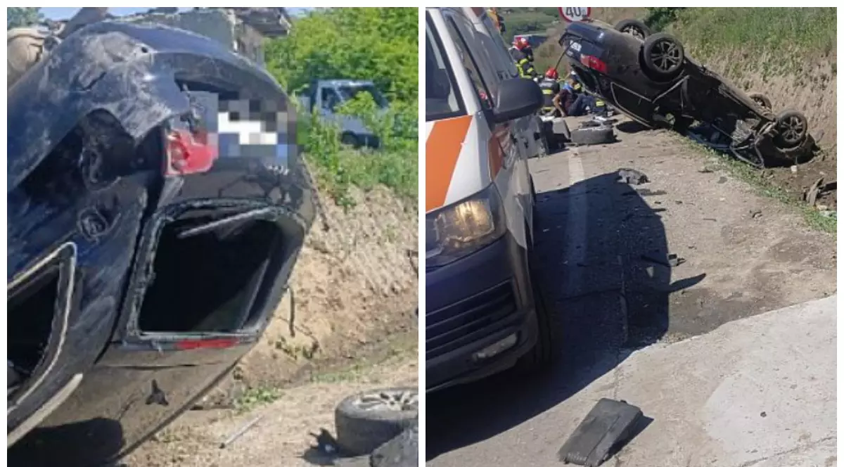 În imagine se văd urmările unui accident rutier grav: un autoturism răsturnat pe plafon pe marginea unui drum, cu avarii majore în partea din spate. În jurul mașinii sunt împrăștiate mai multe fragmente auto și obiecte, iar în partea dreaptă apare o ambulanță.