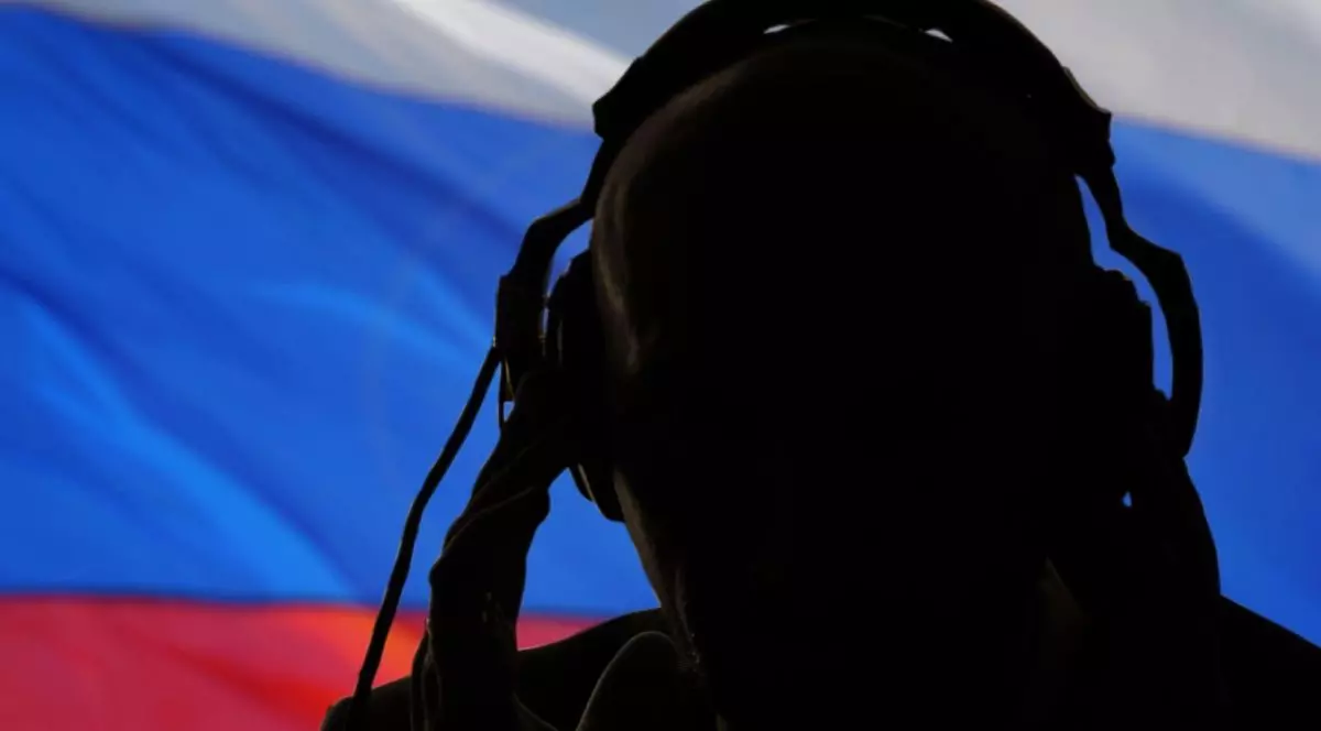 Silueta unui bărbat purtând căști, agent secret care ascultă cu urechea, spion și cercetaș, steag rusesc, lumină de fundal.