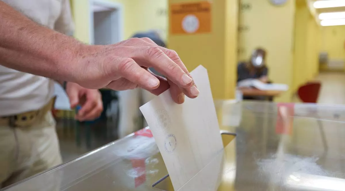 mâna uni cetățean polonez, în timp ce introduce buletinul în urna de vot la alegerile din Polonia, din 2020