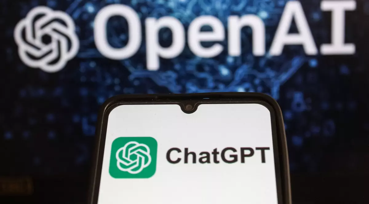 Logo-ul Chat GPT afișat pe ecranul unui telefon, și cel OpenAI, afișat în fața unui fundal albastru cu negru.