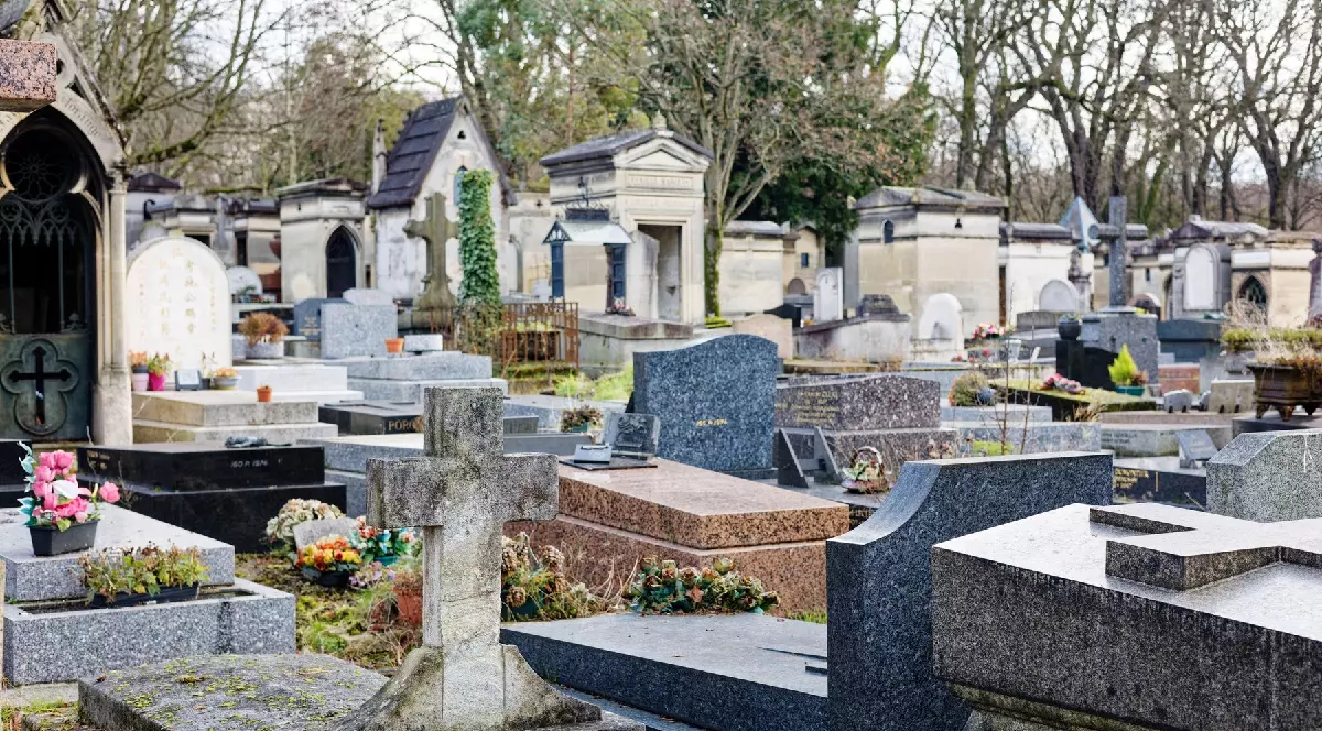 mai multe morminte, unele din marmură, altele pe care cresc flori, încimitirul Père Lachaise
