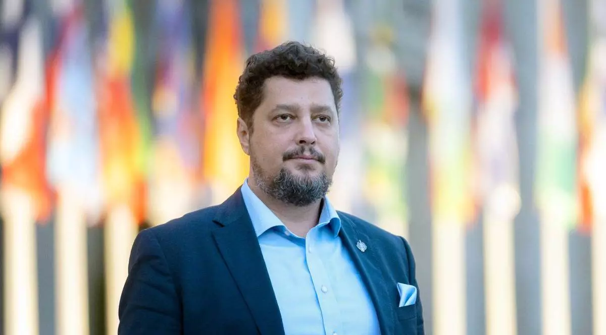 Poză cu Claudiu Târziu. Poartă un sacou albastru și o cămașă bleu