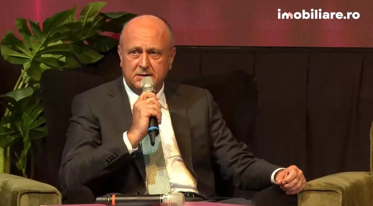 Dan Șucu, în timp ce stă pe un fotoliu, îmbrăcat în costum, la conferința Imobiliare.ro HUB Național 2025