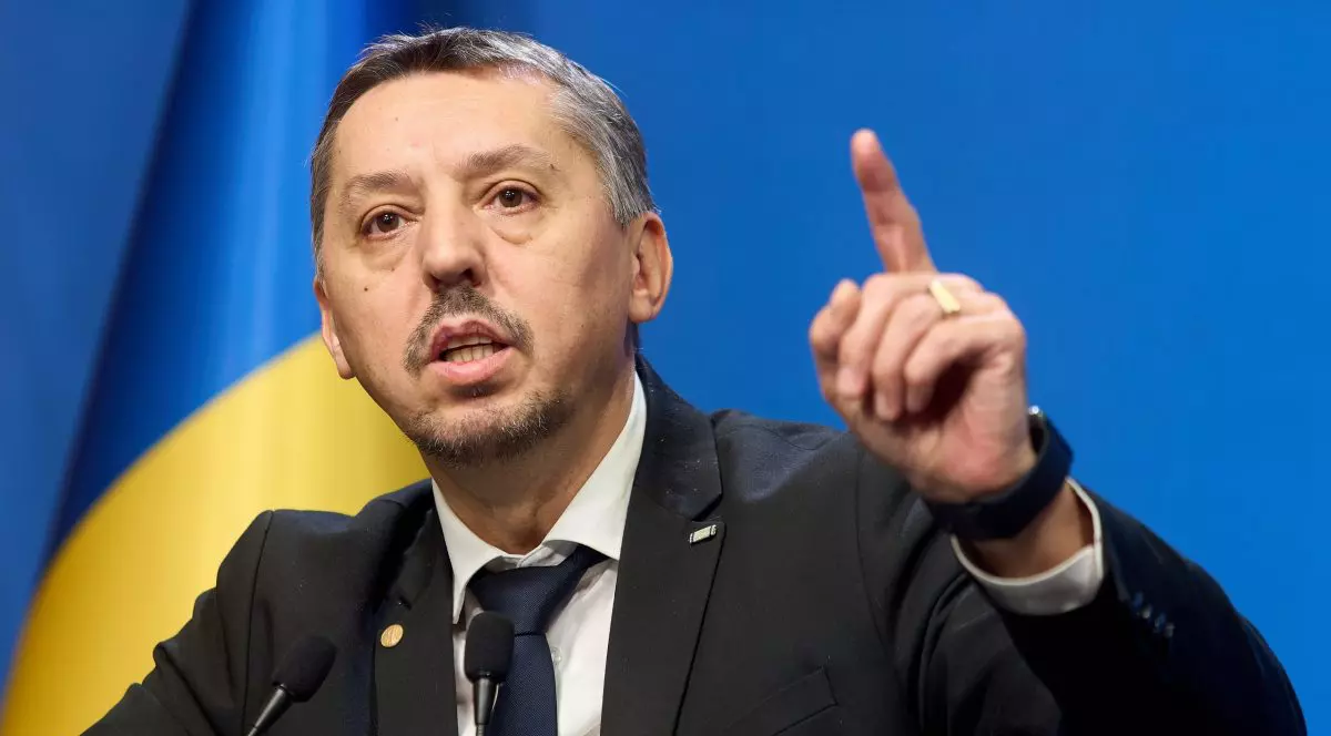 Daniel David, ministrul Educației, cu mâna ridicată vorbind în cadrul unei conferințe de presă