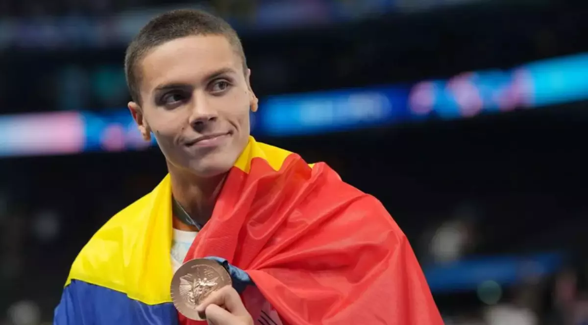 În imagine este ilustrat David Popovici, care poartă tricolorul pe spate