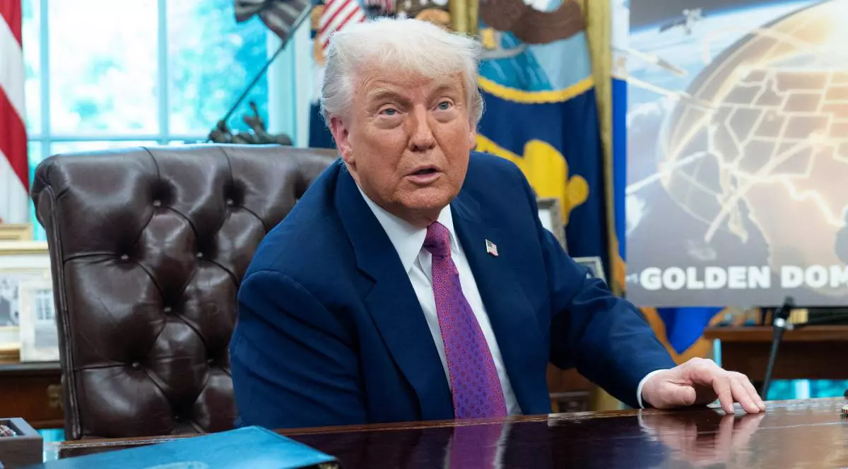 Donald Trump la masă în Biroul Oval de la Casa Albă, îmbrăcat la costum și purtând o cravată mov.