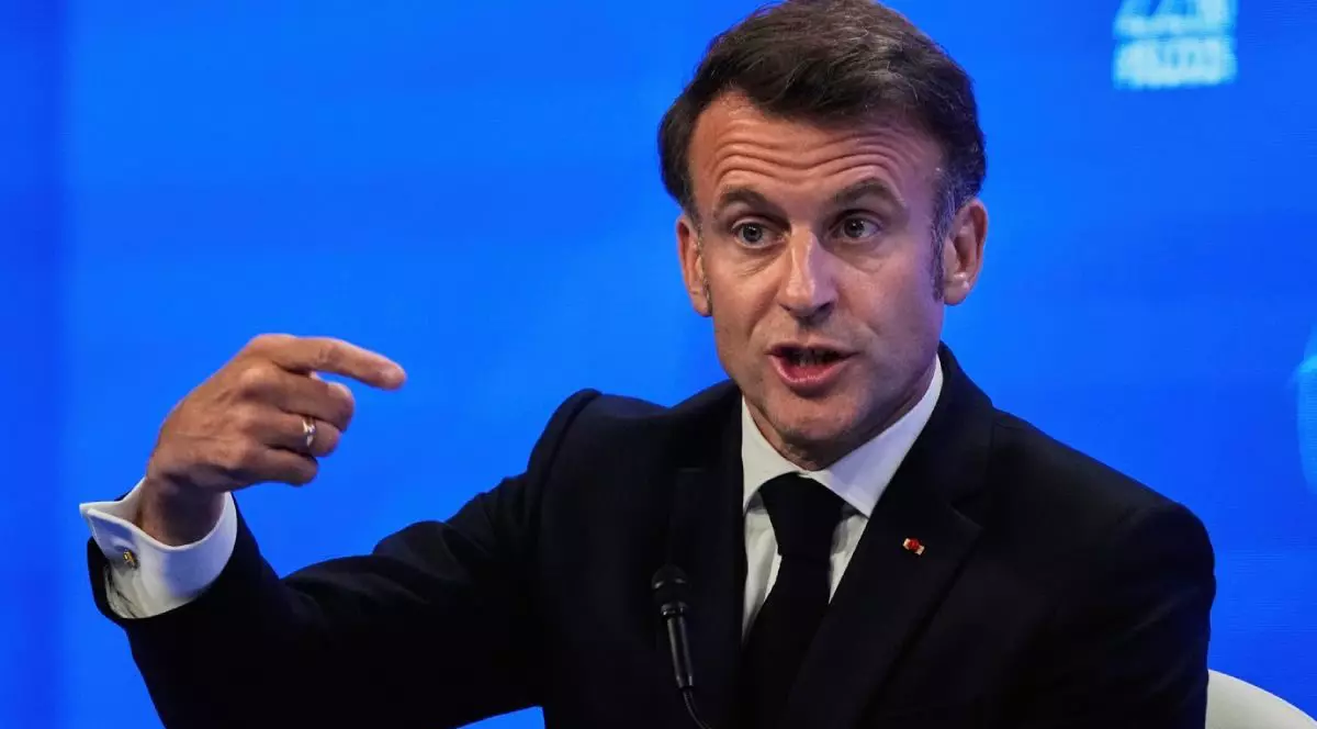 Președintele francez Emmanuel Macron vorbește în fața presei în timpul celui de-al 22-lea summit al Dialogului Shangri-La de la Singapore, vineri, 30 mai 2025. El are mana dreapta ridicata si explica ceva, tinand degetul arătător intins, pe fundal albastru