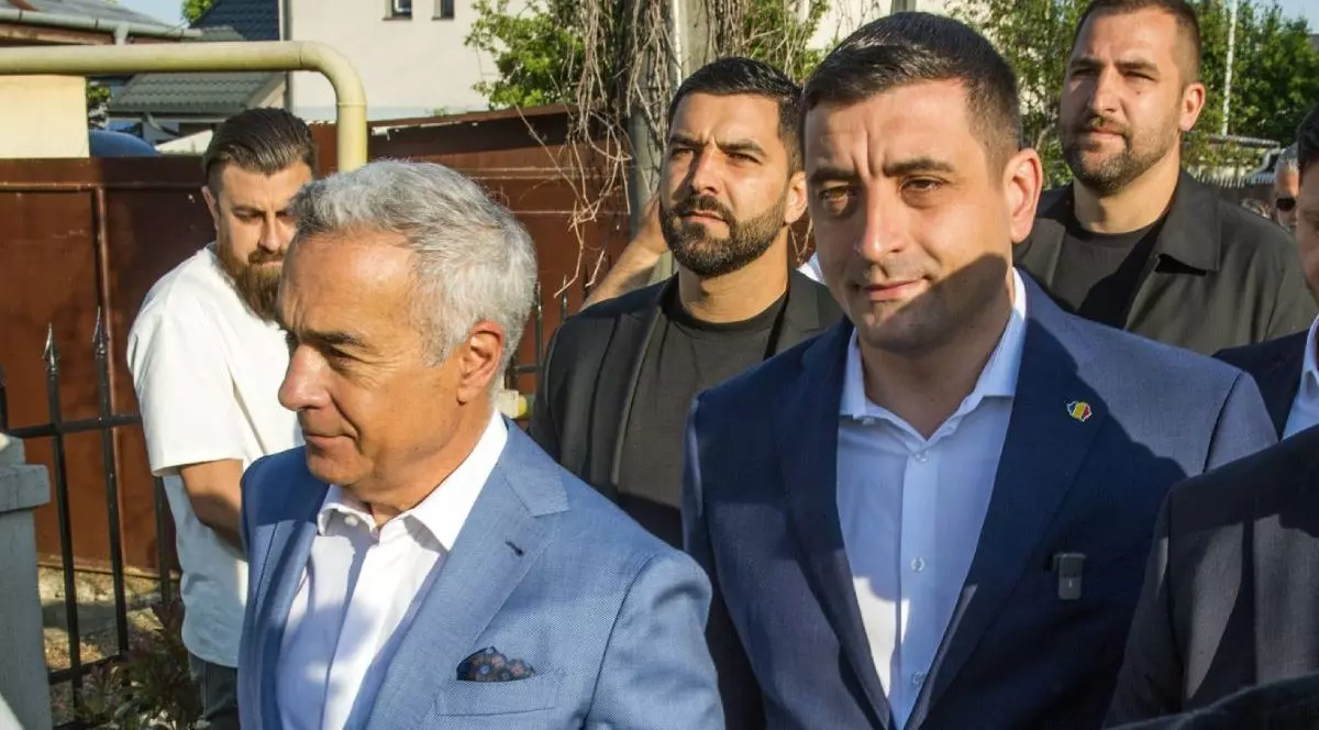 George Simion, dreapta, in sacou negru si cămasă albă, și Călin Georgescu, stanga, in sacou gri cravata si cămasă albă, merg impreună pe stradă spre secția de votare, în spatele lor se vad 3 barbati, Mogosoaia, 4 mai 2025