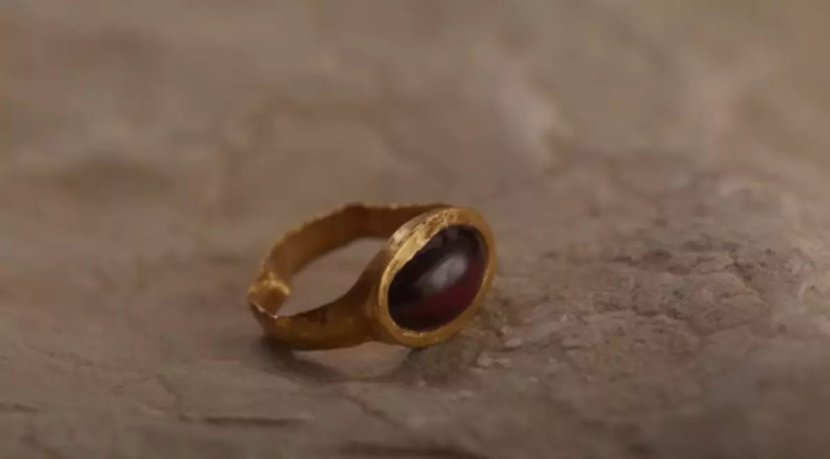 În imagine este ilustrat un inel de aur. Suprafața din interior este maro