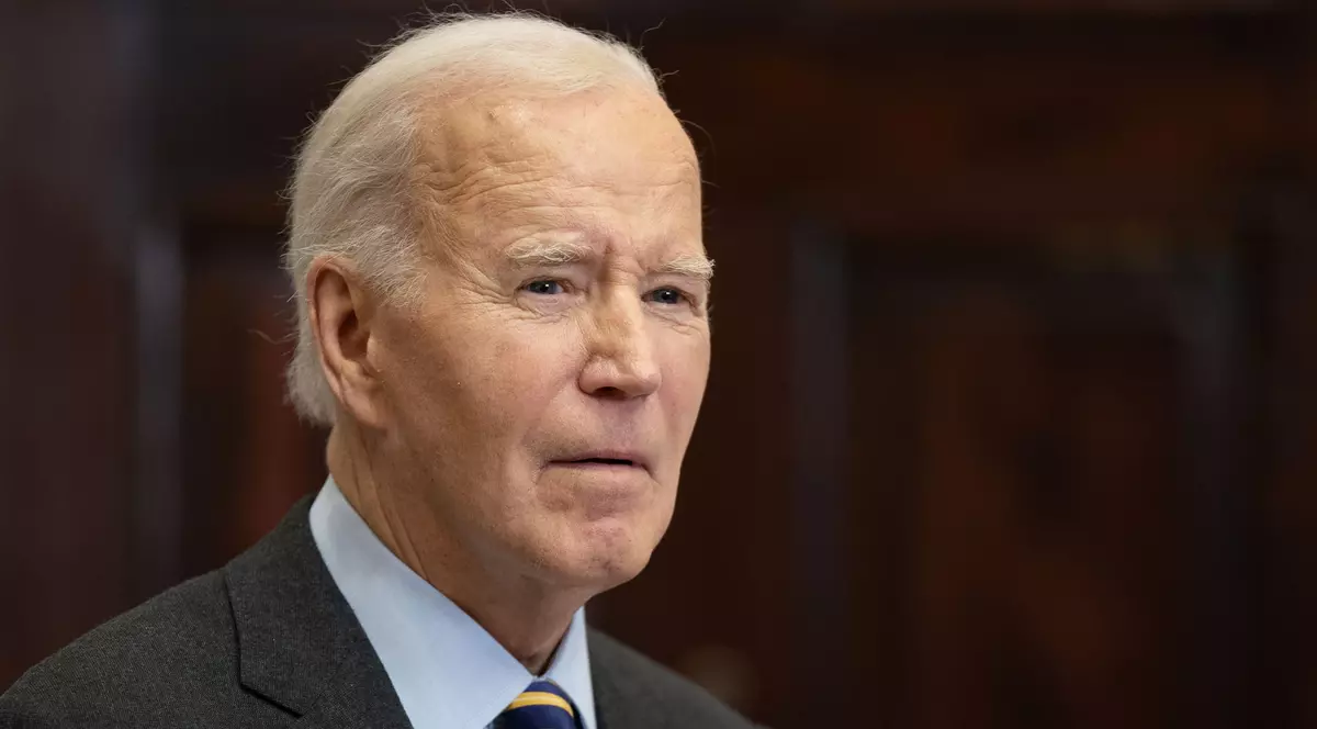 Foto cu Joe Biden purtând o cămașă albastră, cu un sacou negru