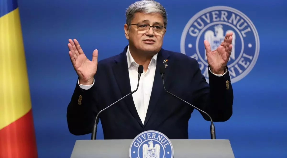 Ministrul Proiectelor Europene, Marcel Boloș, surprins când gesticulează din mâini și vorbește la microfon de la pupitrul Guvernului, la o conferință de presă, vineri, 30 mai 2025