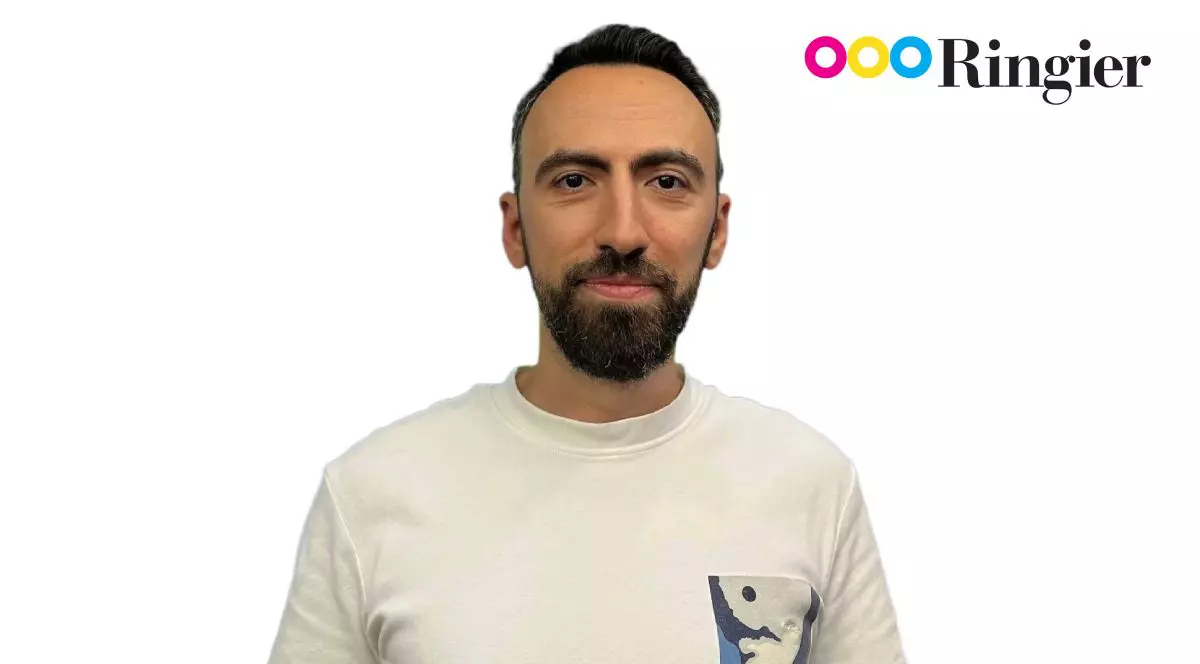 Mihai Badea, îmbrăcat cu un tricou alb, pe fundal alb, cu logo-ul Ringier în dreapta-sus