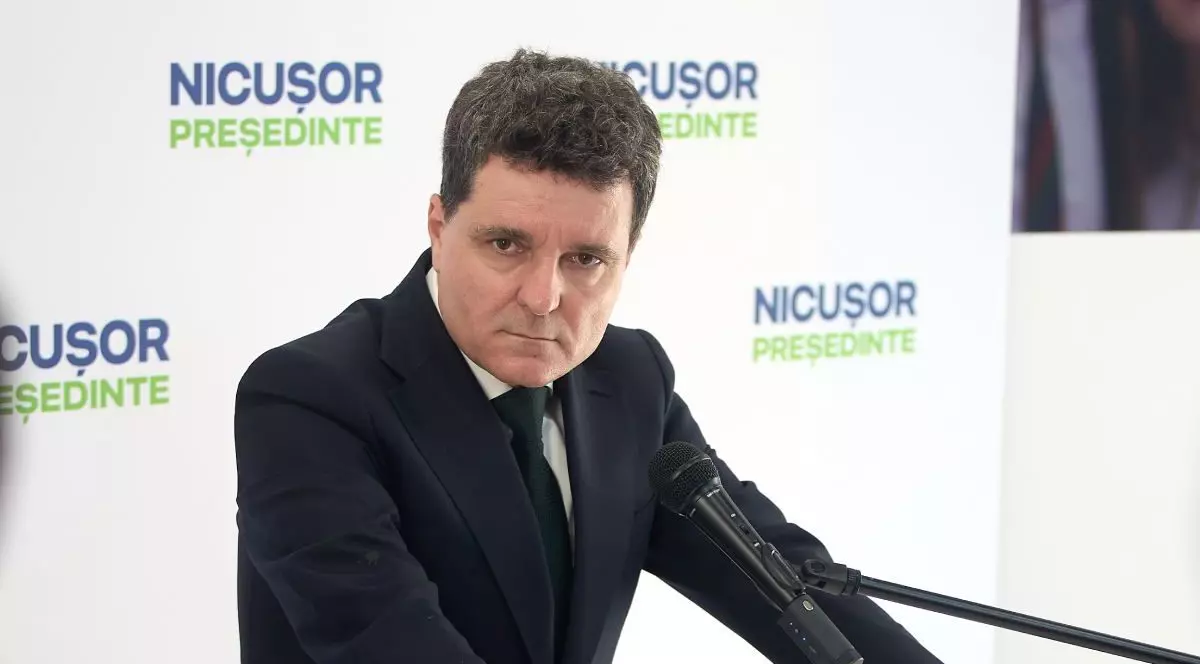 fotografie cu Nicușor Dan in saciu negru, sprijinit cu mainile de un pupitru, cu un microfon in fata, cu un banner alb in spate, pe care scrie Nicusor presedinte