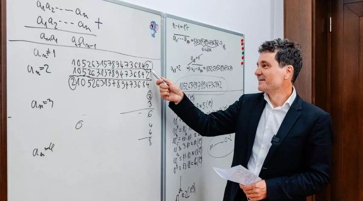 Nicușor Dan, îmbrăcat la costum, stă la tabla de scris și rezolvă probleme la matematică