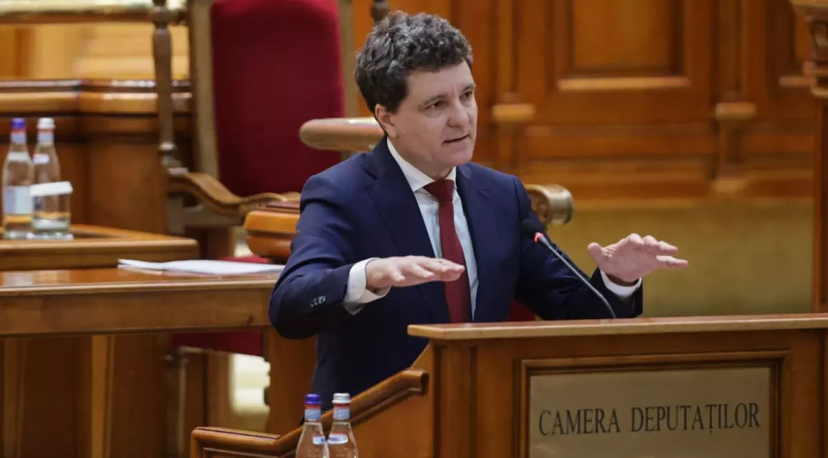 Președintele Nicușor Dan, îmbrăcat la costum și cu cravată roșie, vorbește de la pupitrul Camerei Deputaților și explică cu mâinile, luni, 26 mai 2025, în ziua în care a depus jurământul de credință