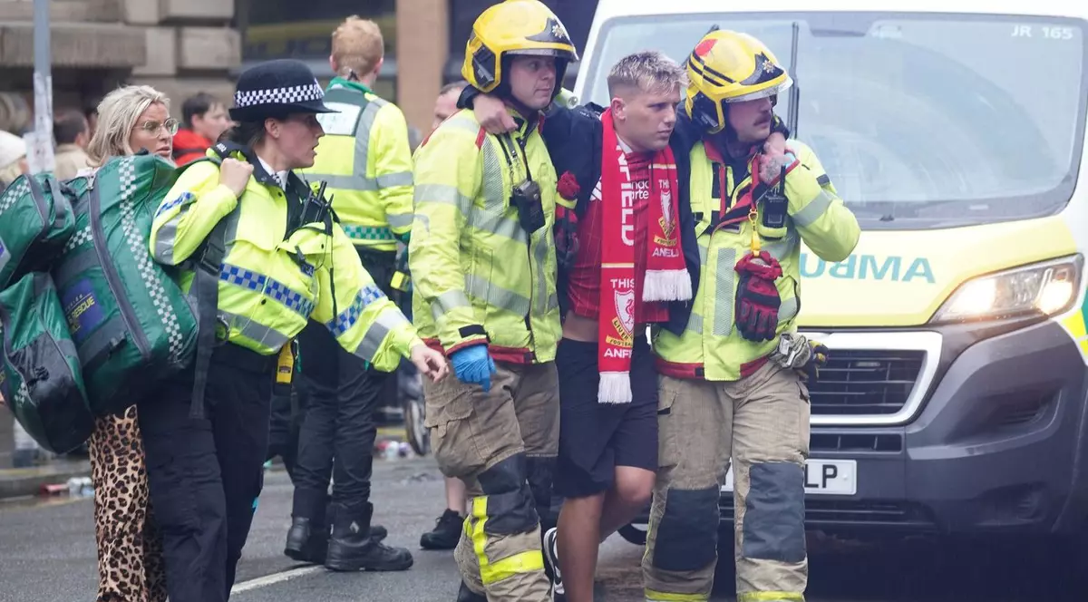 Mai multi suporteri ai echipei FC Liverpool au fost răniți după c eo masina a intrat in multime. In imagine vedem un cetatean ranit transportat de doi lucratori din serviciile de urgenta