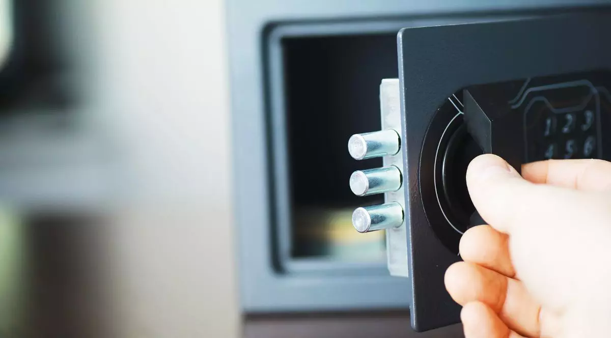 mânp de femeie care deschide un seif metalic