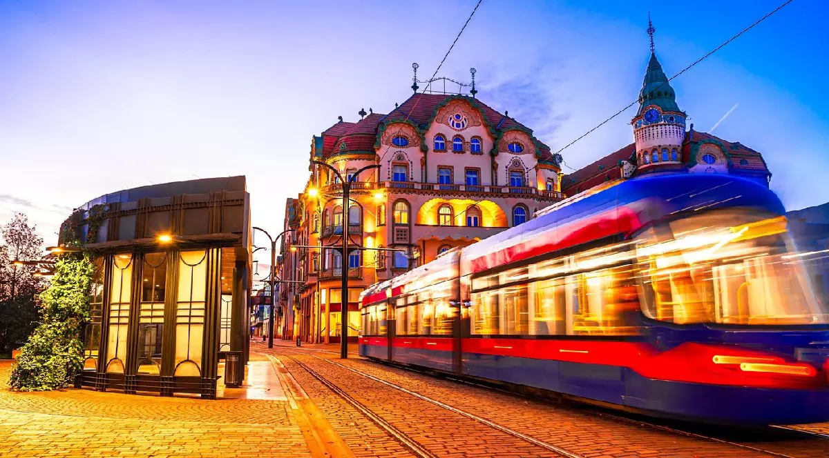 Oradea, România: Dimineața tramvai în mișcare blur în Piața Unirii, cu arhitectura orașului frumos de Crisana, Transilvania, răsărit de soare cer colorat, Europa