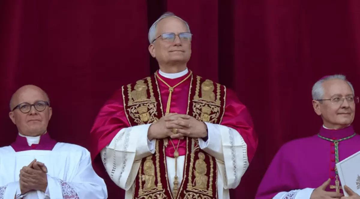 Papa Leon al XIV-lea în timp ce a ieșit la balcon îmbrăcat în straiele papale. În stânga și în dreapta sa se află doi oameni.