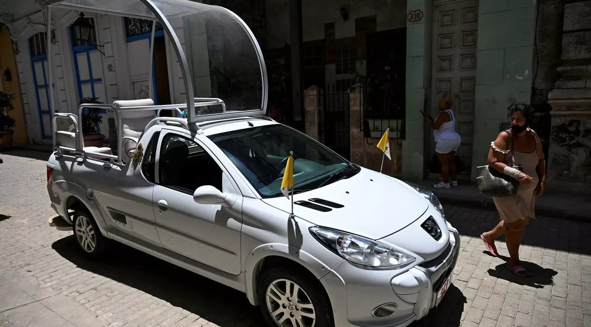Papamobilul Suveranului Pontif surprins pe o stradă din Havana, pe 22 aprilie 2025. O femeie trece pe lângă el