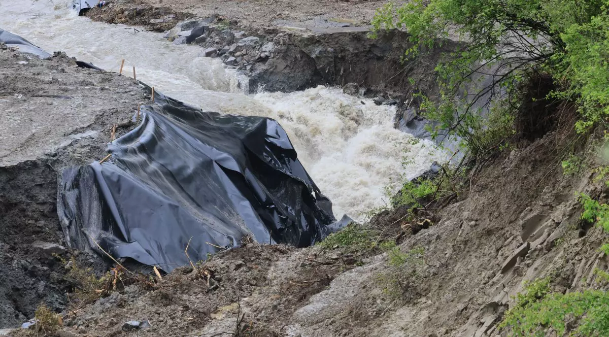 Un celofan negru acopera o parte de pamant, pe langa el trece un suvoi de apa, salina Praid, 28 mai 2025