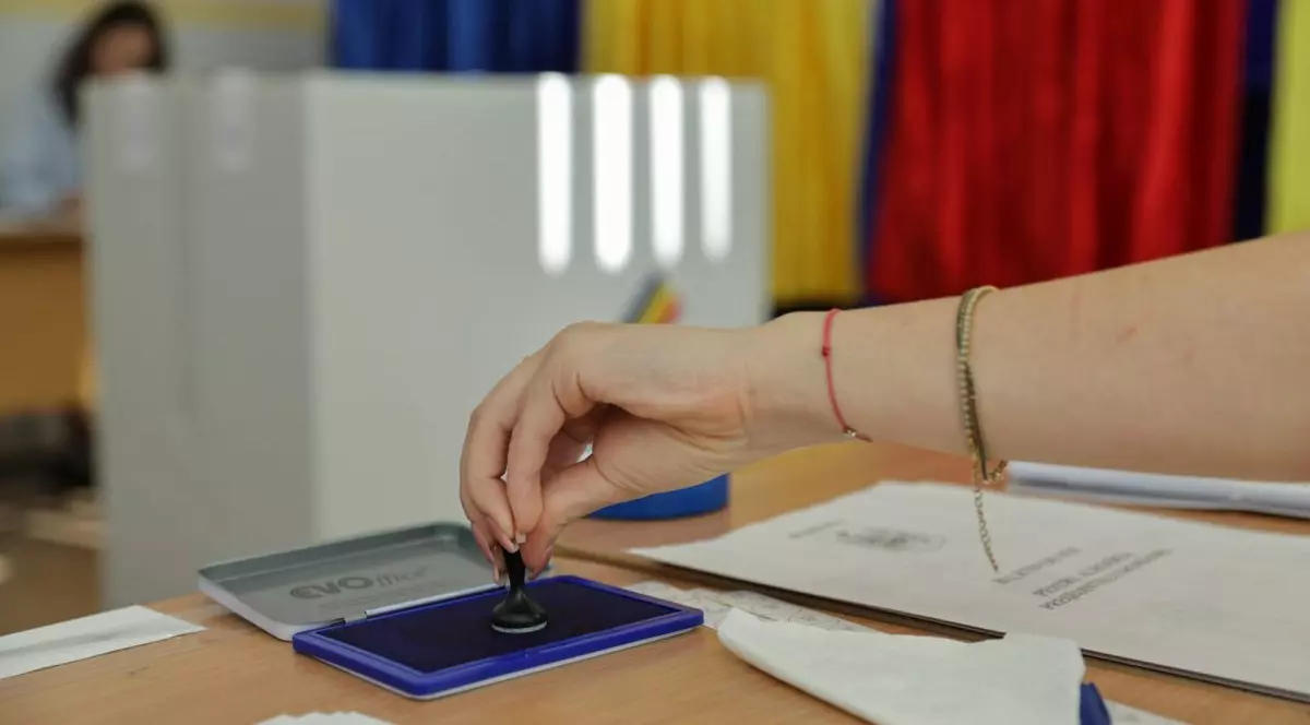 mâna unei femei cu o ștampilă în mână, ân secția de votare