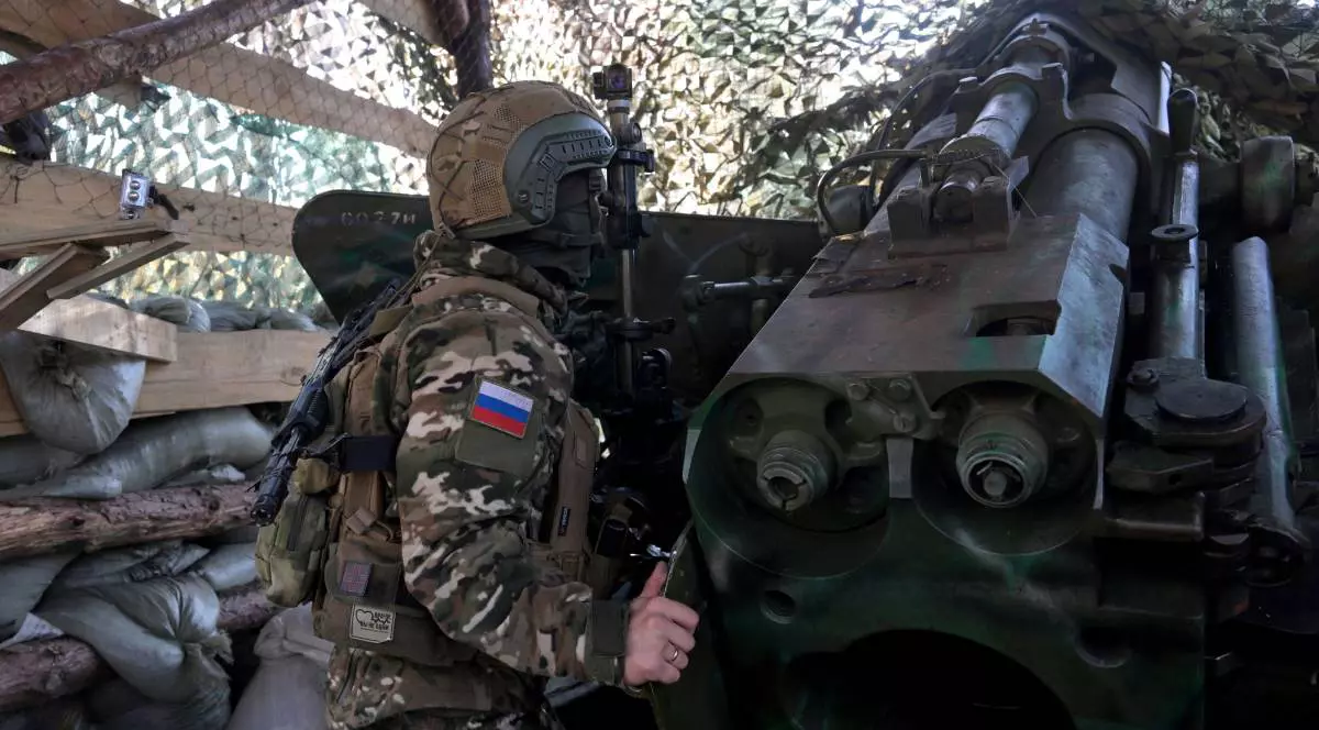 Un soldat rus pe front, stând camuflat lângă un lansator de rachete.