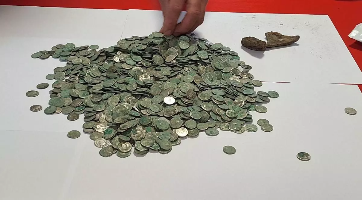 O grămadă de monede romane din argint pe o hârtie albă