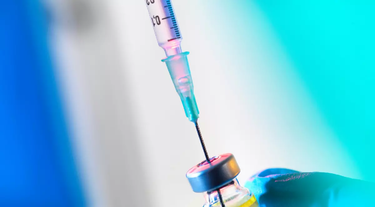 O seringă este introdusă într-un flacon cu vaccin