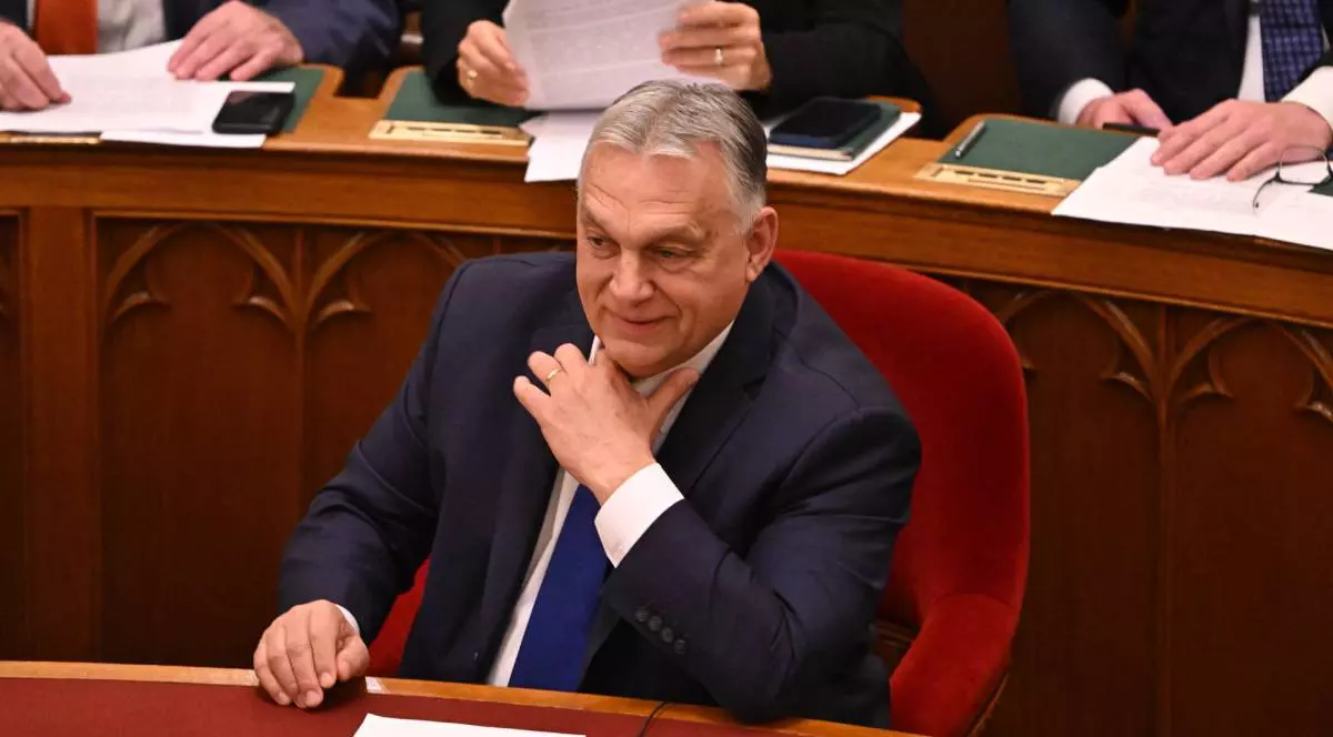 Premierul Viktor Orban, îmbrăcat la costum, cu o cravată albastră, în timp ce stă pe scaun în timpul unui discurs în Parlamentul Ungariei.