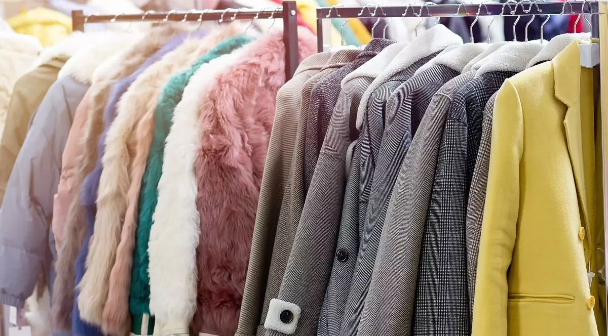 Haine de iarnă și toamnă, geci și paltoane colorate, puse pe umerașe