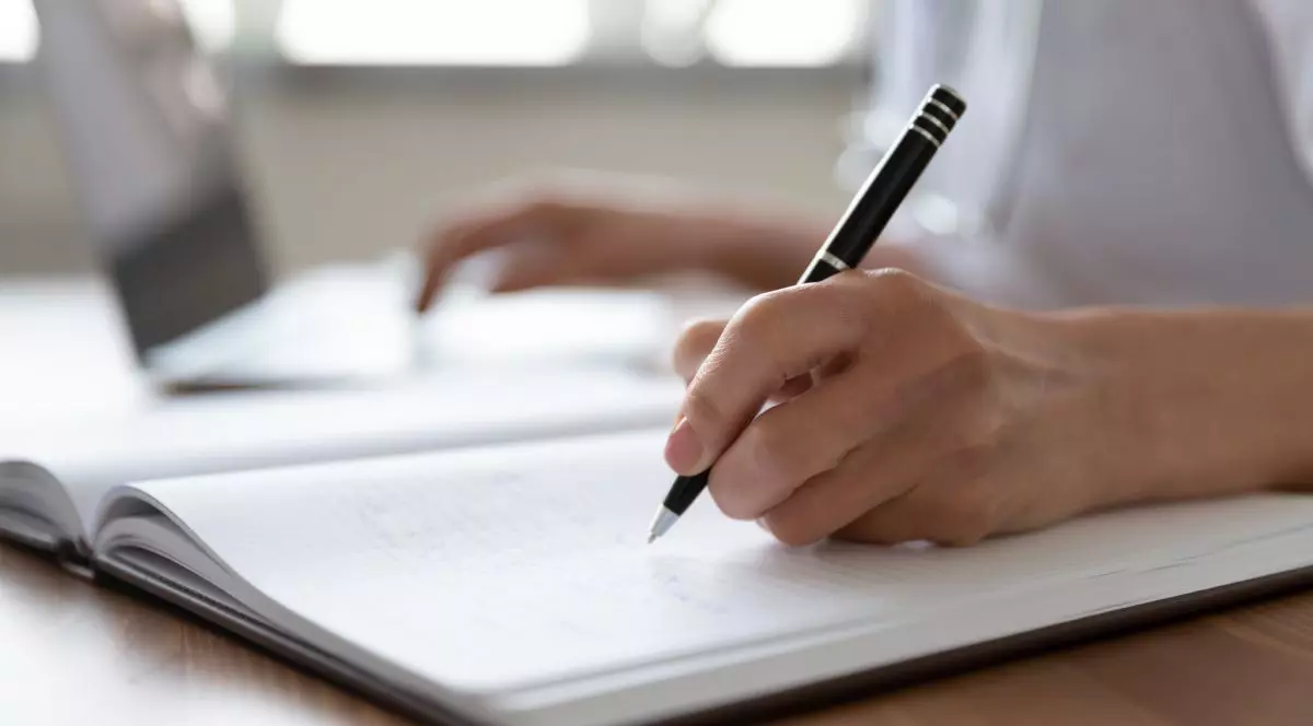 cadru strans cu mana unei persoane care semneaza si completeaza cu pixul un document, conceptul de acte eliberate de medicul de familie