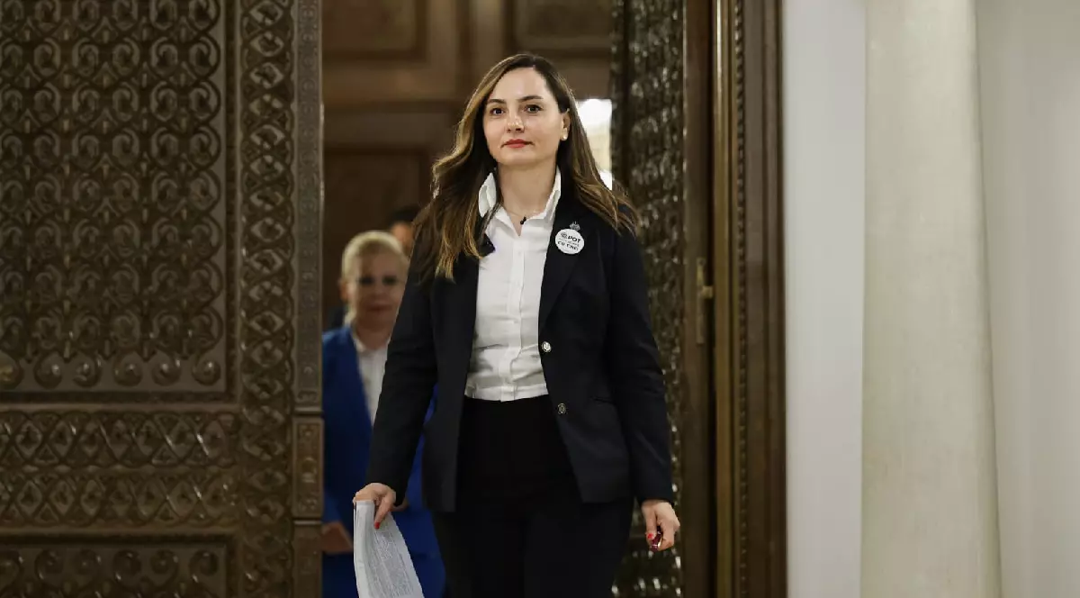 Anamaria Gavrilă poartă un costum business negru cu cămașă albă clasică și sacou