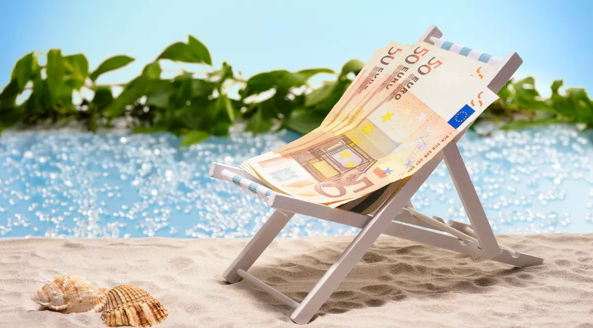 Bancnote de 50 de euro așezate pe un șezlong, pe o plajă